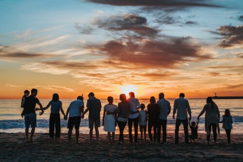 Bild mit Menschen am Strand bei Sonnenuntergang